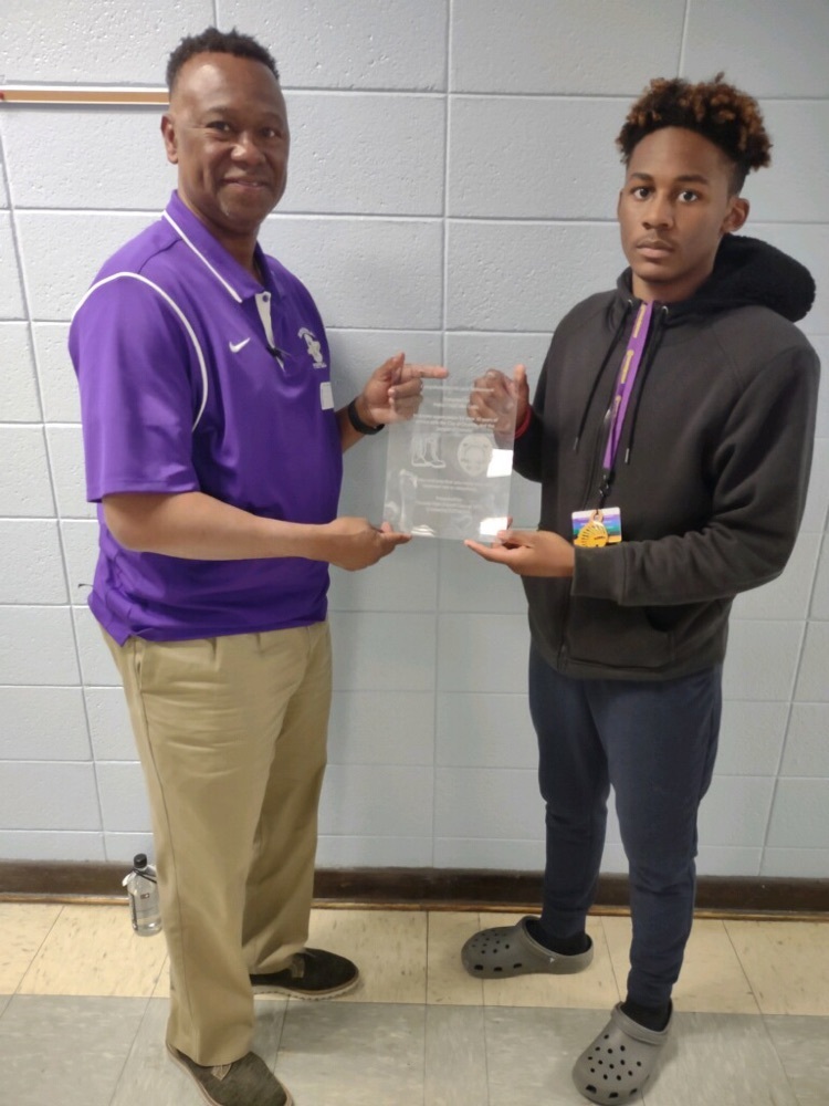 picture of student giving adult a plaque 