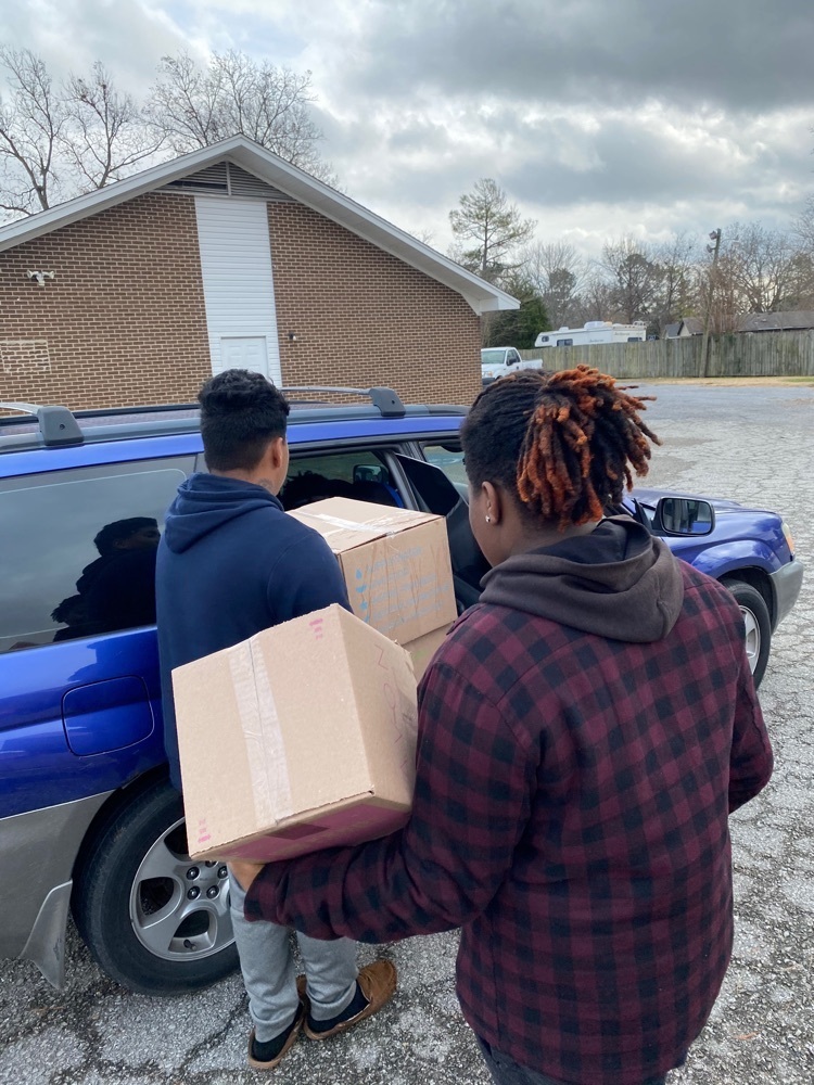 Students volunteer at Westside Ministry food distribution event.