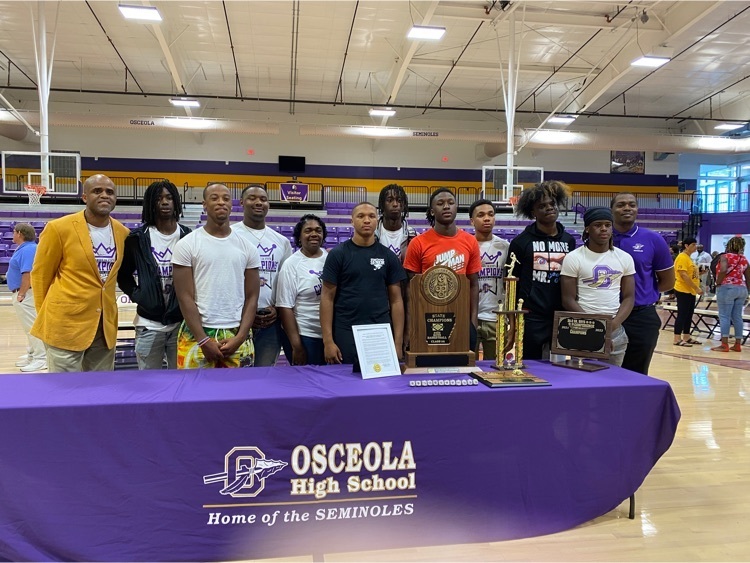 picture of basketball players and coaches with rings and trophies 